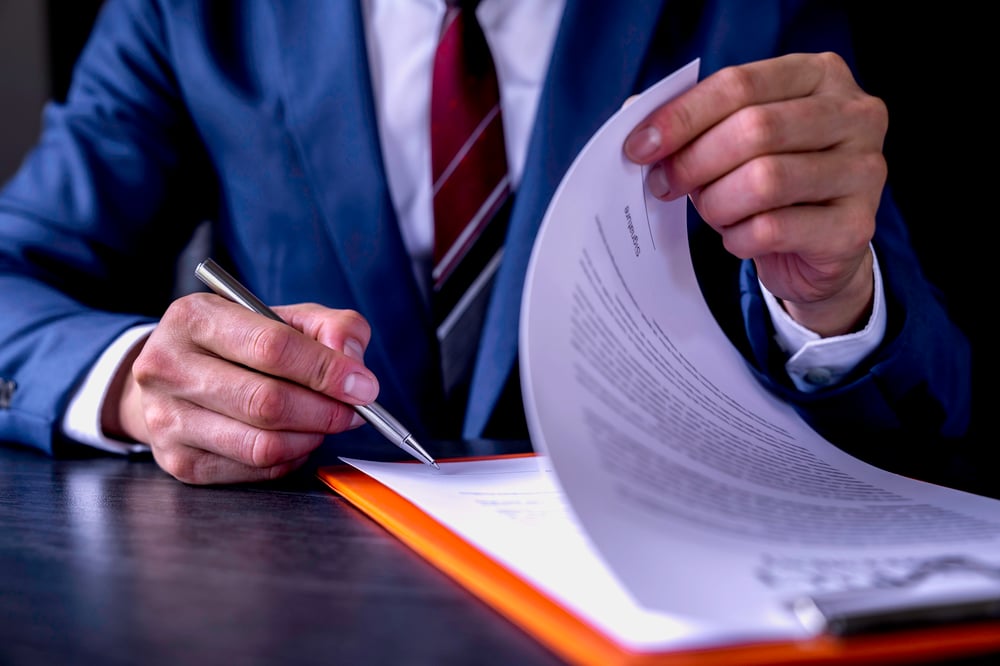 business-man-reading-and-signing-a-business-contra-2023-06-12-20-43-40-utc